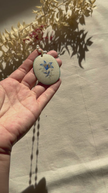 Pendentif vintage en porcelaine Rosenthal sur un brin de fausses perles